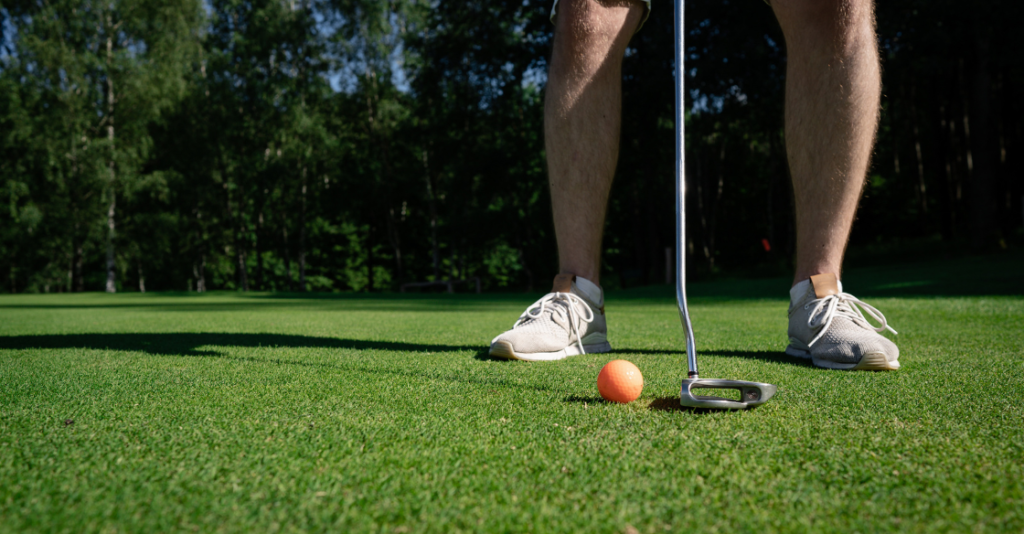 Male golfer plays on artificial putting greens