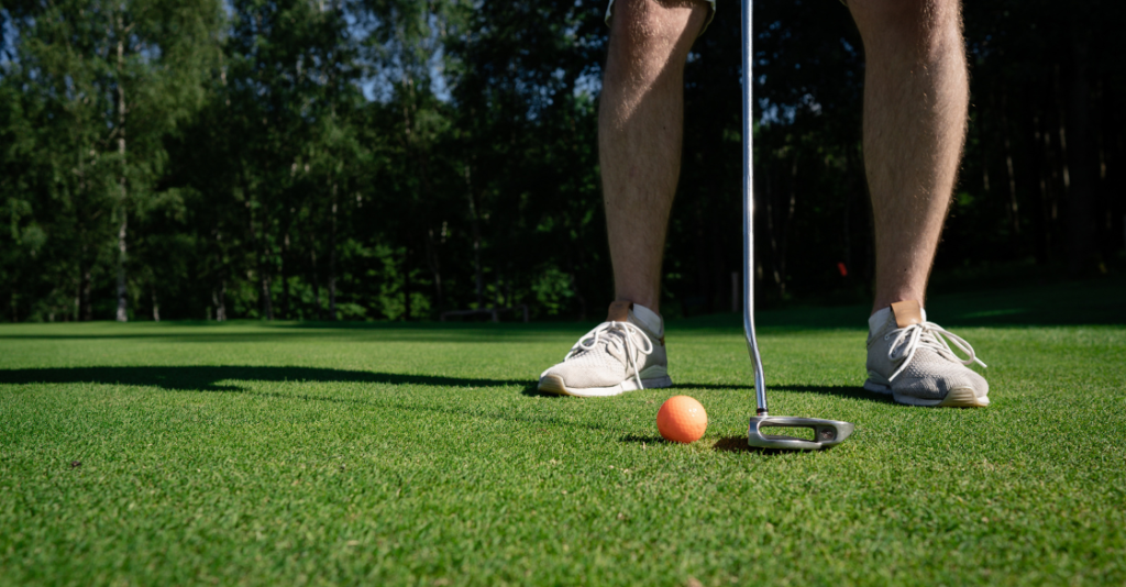 Male golfer plays on artificial putting green