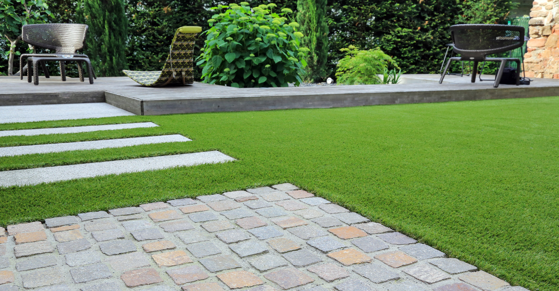 Backyard patio with pavers, stone, and artificial grass